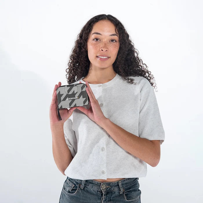 Woman holding a Sherpani Barcelona Houndstooth Anti-Theft Mini Wallet on white backdrop.  #color_houndstooth-print