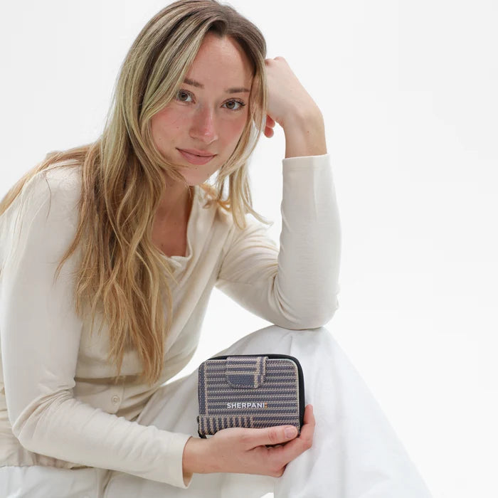 Woman holding a Sherpani Barcelona Passport Anti-Theft Mini Wallet on white backdrop.  #color_passport-print