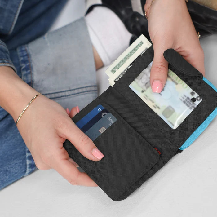 Woman holding open a Sherpani Barcelona Chromatic Black RFID Mini Wallet on white backdrop.  #color_chromatic-black