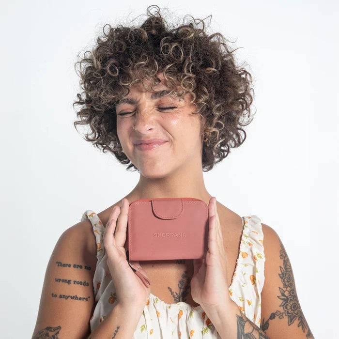 Woman holding a Sherpani Barcelona Desert Pink RFID Mini Wallet on white backdrop.  #color_desert-pink
