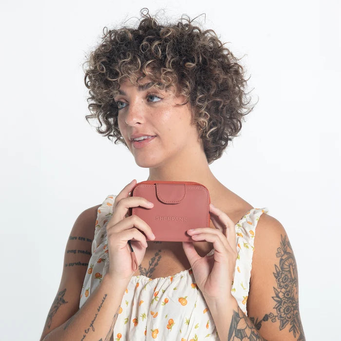 Woman holding a Sherpani Barcelona Desert Pink RFID Mini Wallet on white backdrop.   #color_desert-pink