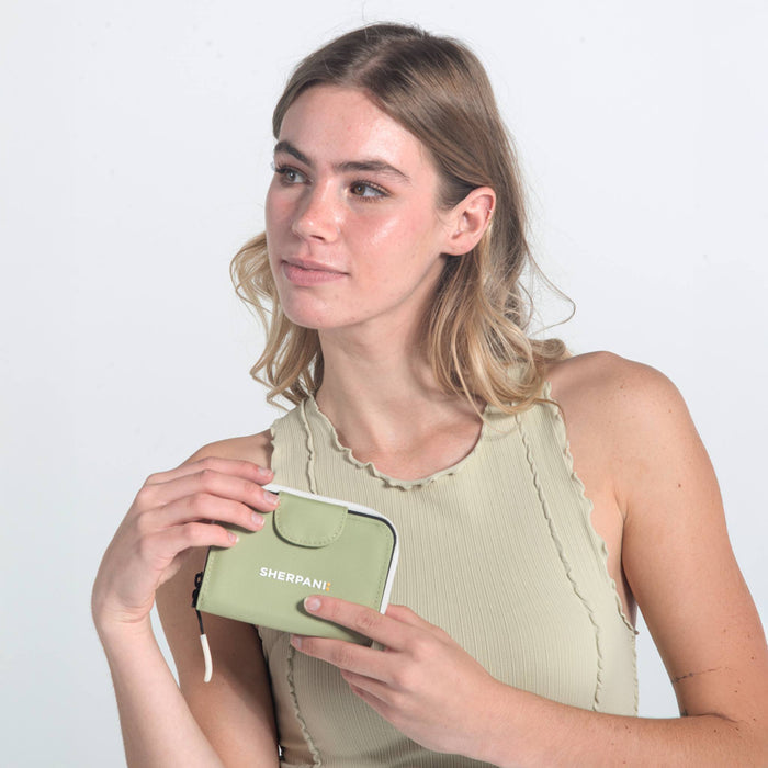 Woman holding a Sherpani Barcelona Palm Green RFID Mini Wallet on white backdrop.  #color_palm-green
