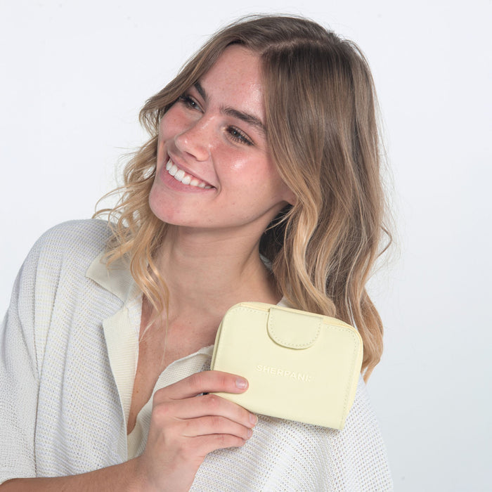 Woman holding a Sherpani Barcelona Sol Yellow RFID Mini Wallet on white backdrop. #color_sol-yellow