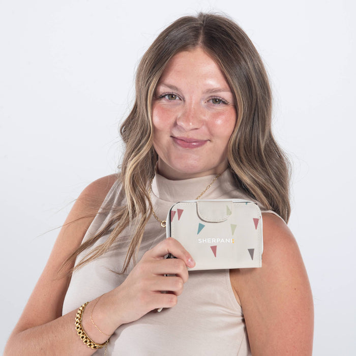Woman holding a Sherpani Barcelona Terrazzo Print RFID Mini Wallet on white backdrop.  #color_terrazzo-print