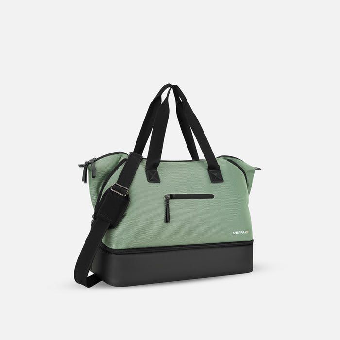 A Sherpani Boston Aloe Mist Green Anti-theft Weekender, 3/4 view showing strap and lockable pocket on white background. #color_aloe-mist-green
