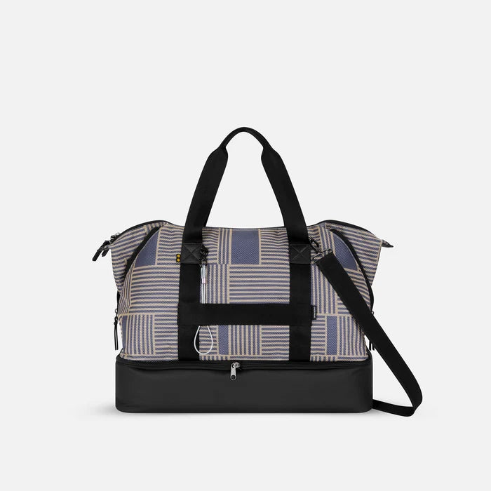 A Sherpani Boston Passport Anti-theft Weekender, back view showing luggage strap & strap options on white backdrop.  #color_passport-print