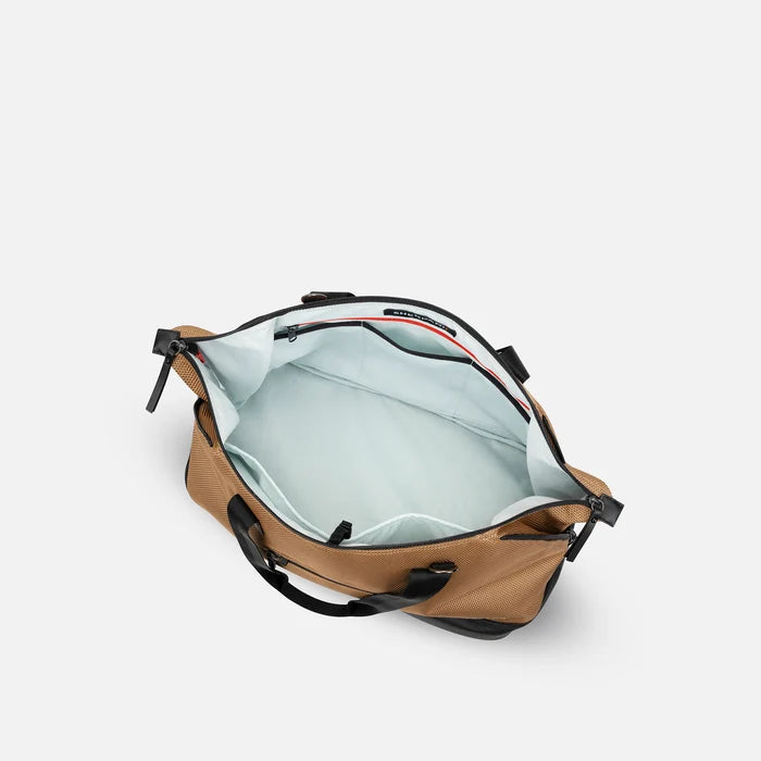 A Sherpani Boston Sand Anti-theft Weekender, above view showing inside main pocket on white backdrop.  #color_sand-tan