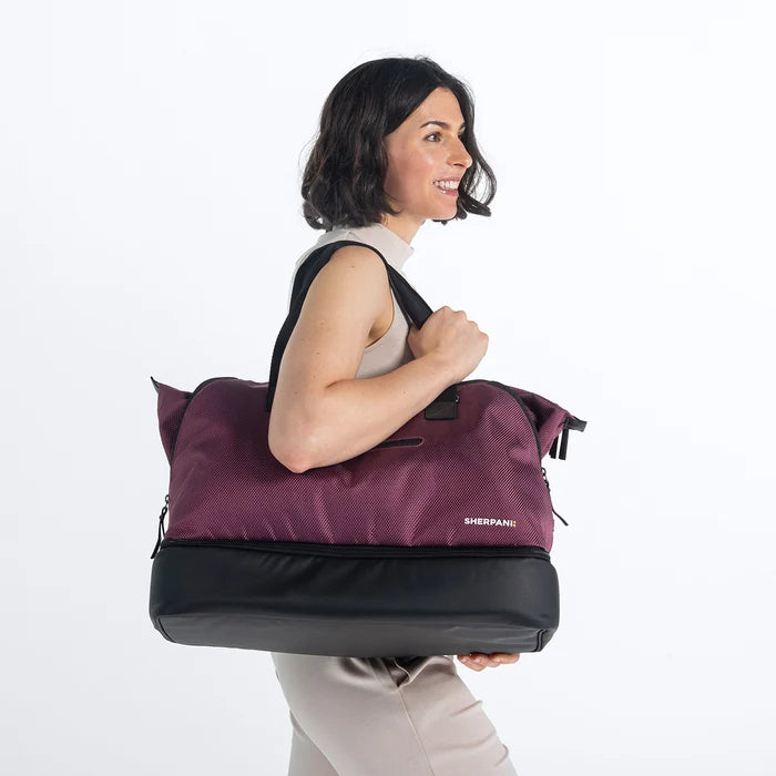A woman wearing a Sherpani Boston Straw Beige Anti-theft Weekender against a white background. #color_smoky-orchid-pink