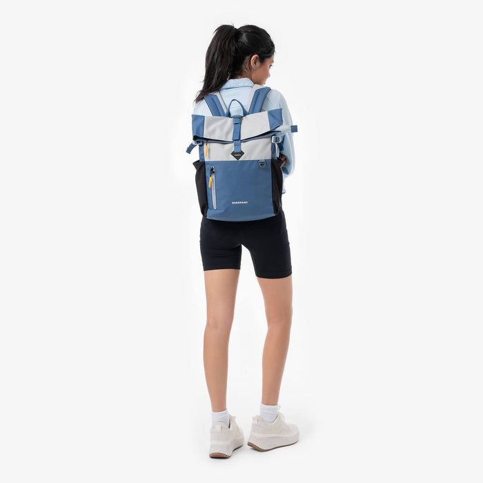 Woman wearing a Sherpani Cabo Seastone Day Pack against a white background. #color_seastone
