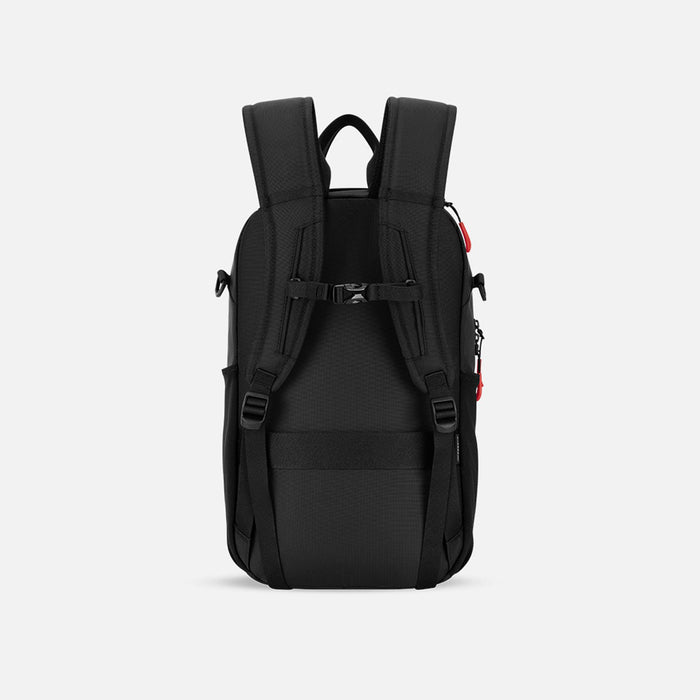 A Sherpani Camden Chromatic Black Backpack, back view showing the shoulder strap and a luggage strap on a white background. #color_chromatic-black