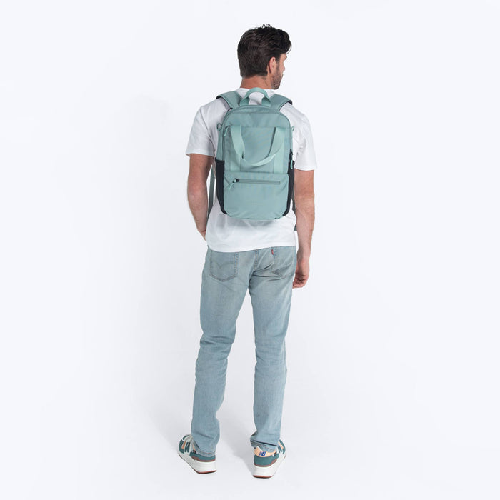Man wearing a Sherpani Camden Surf Blue Backpack on his back against white background.  #color_surf-blue