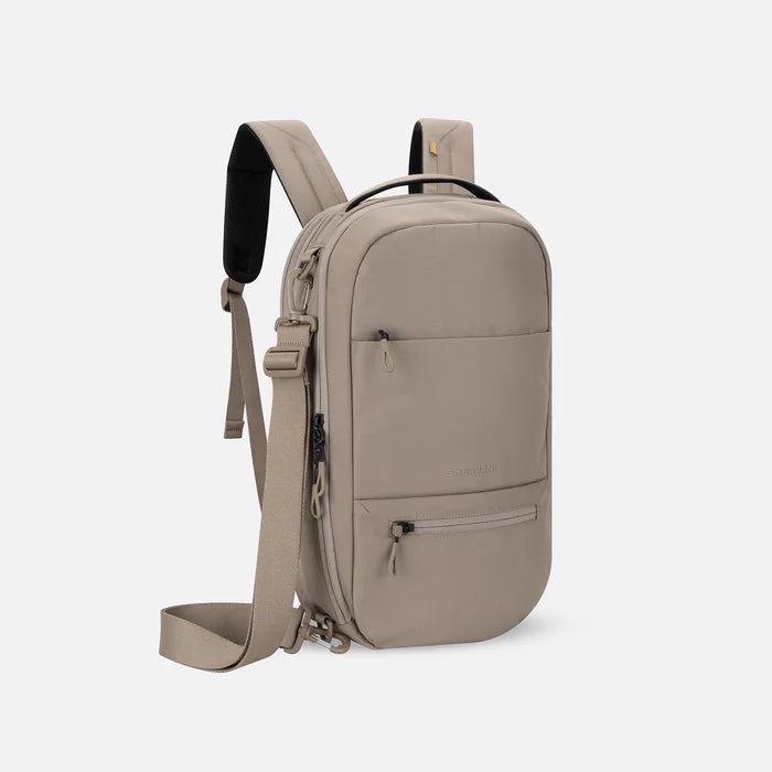 A Sherpani Camden Dune Ultimate Backpack, 3/4 view showing various pockets and strap options on white backdrop. #color_dune-tan