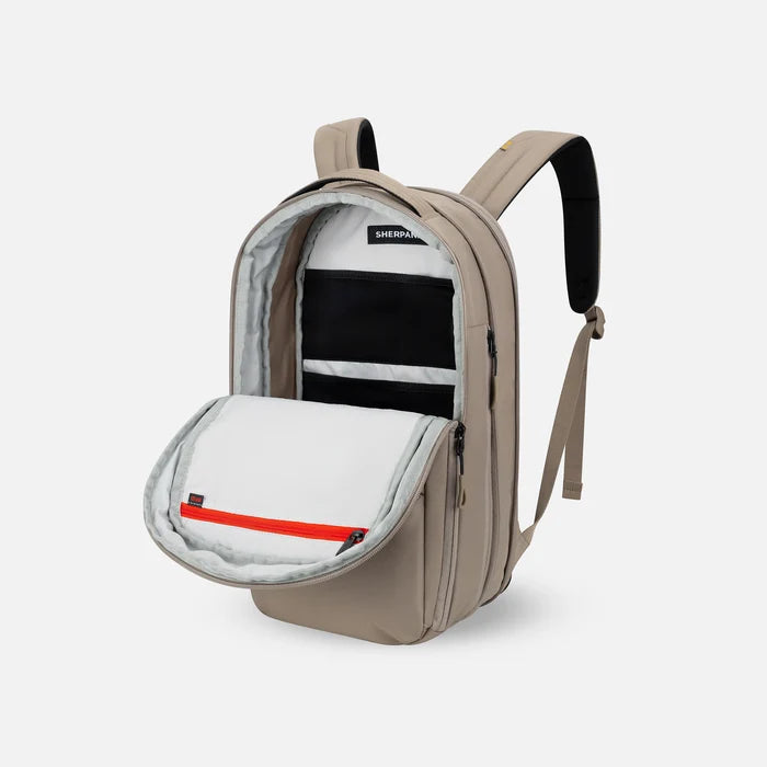 A Sherpani Camden Dune Ultimate Backpack, 3/4 view showing inside of main pocket on a white background.    #color_dune-tan