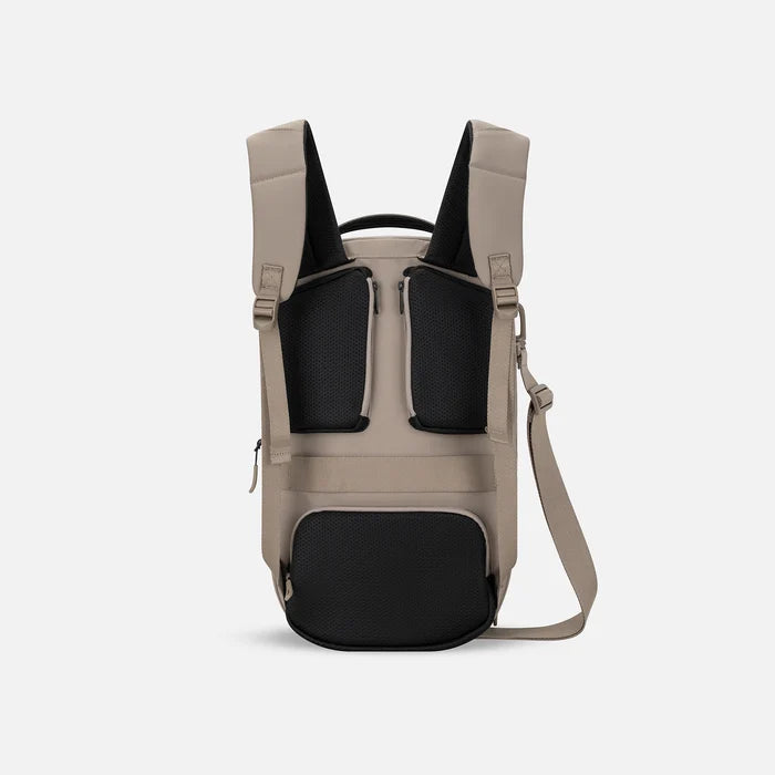A Sherpani Camden Dune Ultimate Backpack, back view showing shoulder straps and luggage strap on white background.  #color_dune-tan