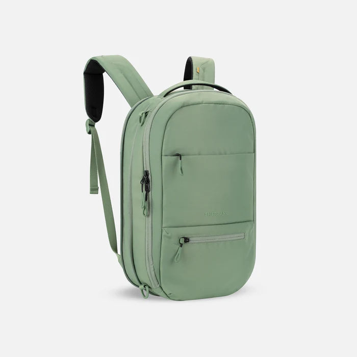 A Sherpani Camden Olivine Ultimate Backpack, 3/4 view showing unzipped extender and strap options on white backdrop. #color_olivine-green