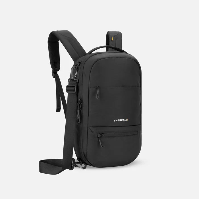 A Sherpani Camden Raven Black Ultimate Backpack, 3/4 view showing various pockets and strap options on white backdrop. #color_raven-black