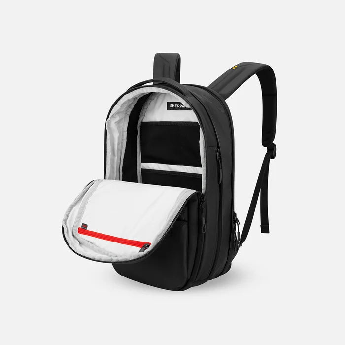 A Sherpani Camden Raven Black Ultimate Backpack, 3/4 view showing inside of main pocket on a white background.    #color_raven-black