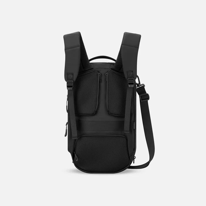 A Sherpani Camden Raven Black Ultimate Backpack, back view showing shoulder straps and luggage strap on white background. #color_raven-black