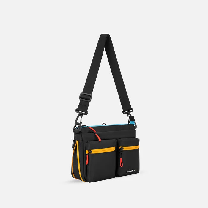 A Sherpani Ceara Chromatic Black Expandable Crossbody, 3/4 view showing two front pockets and the open expandable pocket on a white background.  #color_chromatic-black