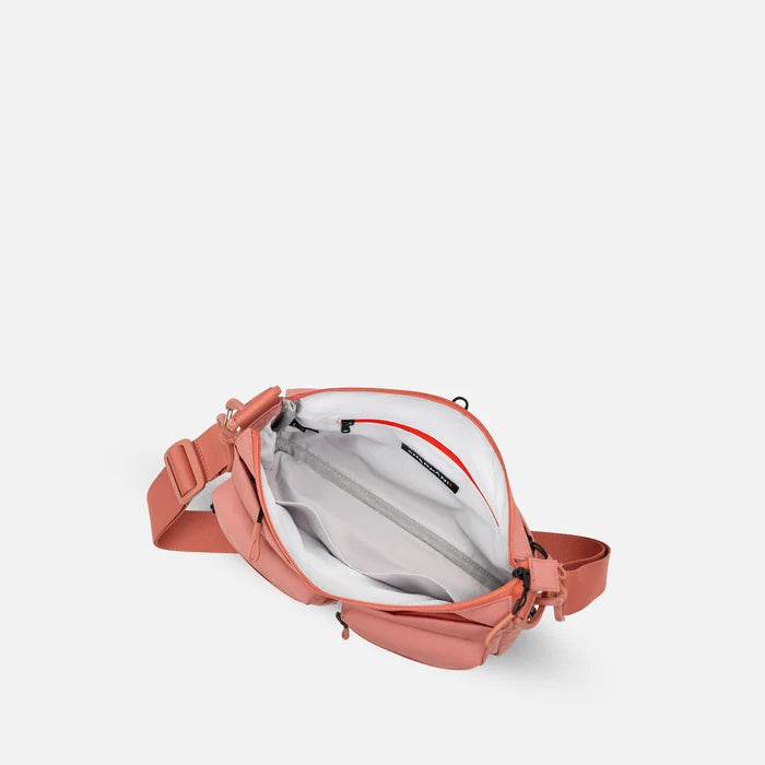 A Sherpani Ceara Desert Pink Expandable Crossbody, above view showing all inside pockets on a white background.   #color_desert-pink