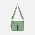 A Sherpani Ceara Olivine Expandable Crossbody, front view showing two front pockets and adjustable strap on a white background.  #color_olivine-green