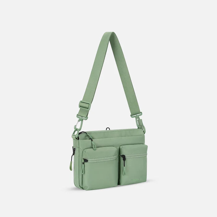 A Sherpani Ceara Olivine Expandable Crossbody, 3/4 view showing two front pockets and the closed expandable pocket on a white background.    #color_olivine-green