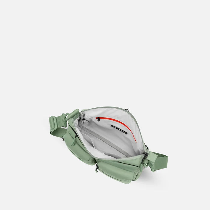 A Sherpani Ceara Olivine Expandable Crossbody, above view showing all inside pockets on a white background.   #color_olivine-green