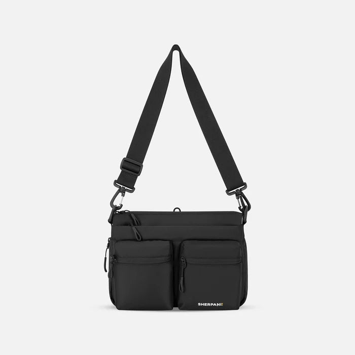 A Sherpani Ceara Raven Black Expandable Crossbody, front view showing two front pockets and adjustable strap on a white background.  #color_raven-black