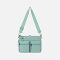 A Sherpani Ceara Surf Blue Expandable Crossbody, front view showing two front pockets and adjustable strap on a white background.  #color_surf-blue