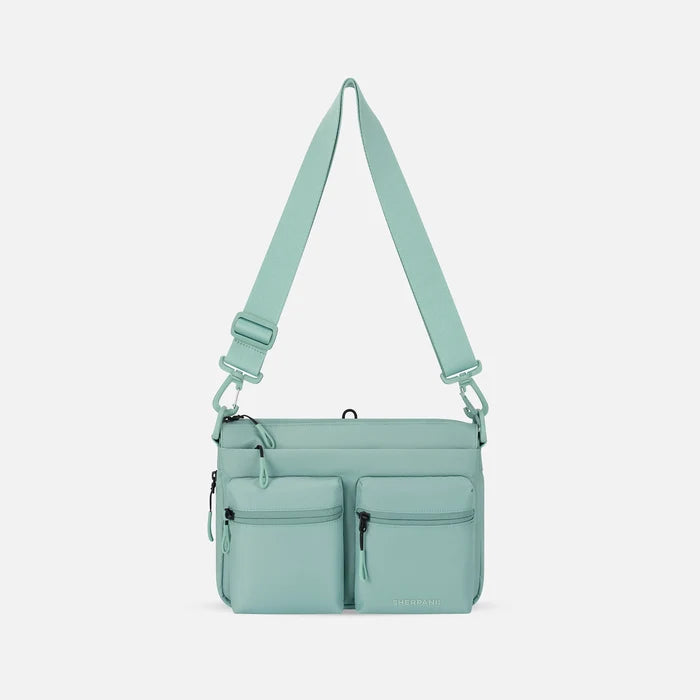 A Sherpani Ceara Surf Blue Expandable Crossbody, front view showing two front pockets and adjustable strap on a white background.  #color_surf-blue