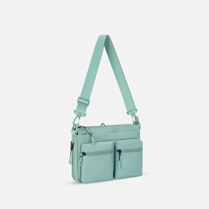 A Sherpani Ceara Surf Blue Expandable Crossbody, 3/4 view showing two front pockets and the closed expandable pocket on a white background.    #color_surf-blue
