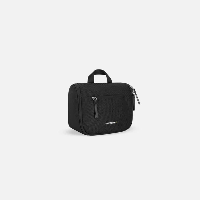 A Sherpani Co-Pilot Carbon Black Travel Toiletry Case, 3/4 view showing handheld strap and zipper pockets on white backdrop. #color_carbon-black