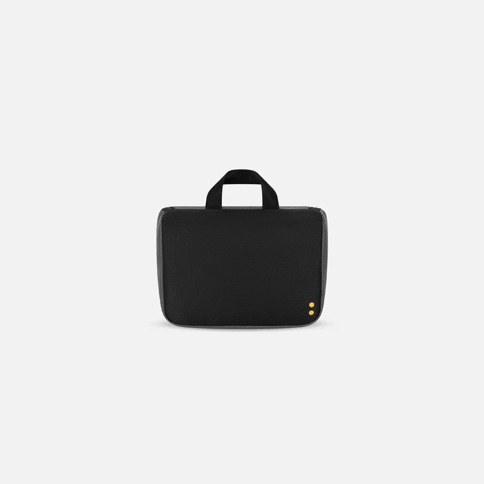 A Sherpani Co-Pilot Granite Travel Toiletry Case, back view showing black backside on white backdrop. #color_granite-grey