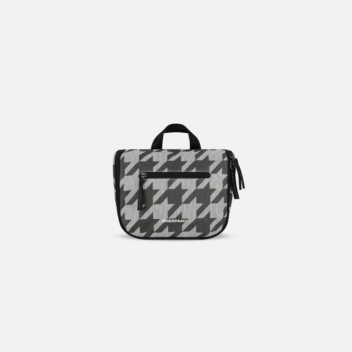 A Sherpani Co-Pilot Houndstooth Travel Toiletry Case, 3/4 view showing interior pockets  against white backdrop. #color_houndstooth-print