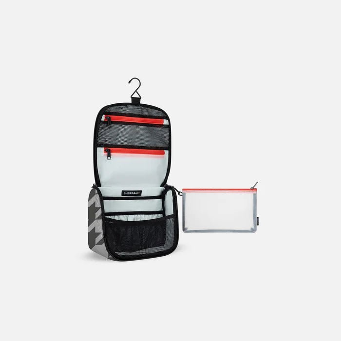 A Sherpani Co-Pilot Houndstooth Travel Toiletry Case, 3/4 view showing interior pockets against white backdrop. #color_houndstooth-print