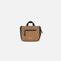 A Sherpani Co-Pilot Sand Travel Toiletry Case, front view showing handheld strap and zipper pockets on white backdrop. #color_sand-tan
