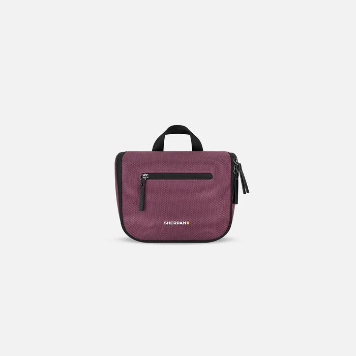 A Sherpani Co-Pilot Smoky Orchid Travel Toiletry Case, front view showing handheld strap and zipper pockets on white backdrop. #color_smoky-orchid-pink