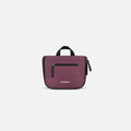 A Sherpani Co-Pilot Smoky Orchid Travel Toiletry Case, front view showing handheld strap and zipper pockets on white backdrop. #color_smoky-orchid-pink