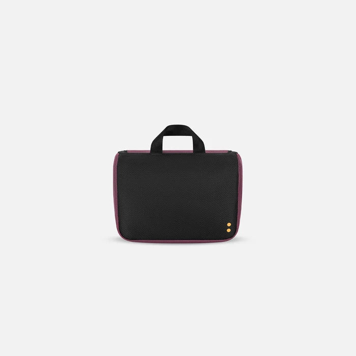 A Sherpani Co-Pilot Smoky Orchid Travel Toiletry Case, back view showing black backside on white backdrop. #color_smoky-orchid-pink