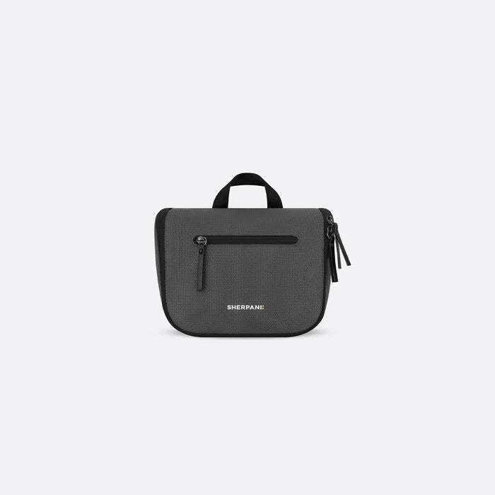 A Sherpani Co-Pilot Granite Travel Toiletry Case, front view showing handheld strap and zipper pockets on white backdrop. #color_granite-grey
