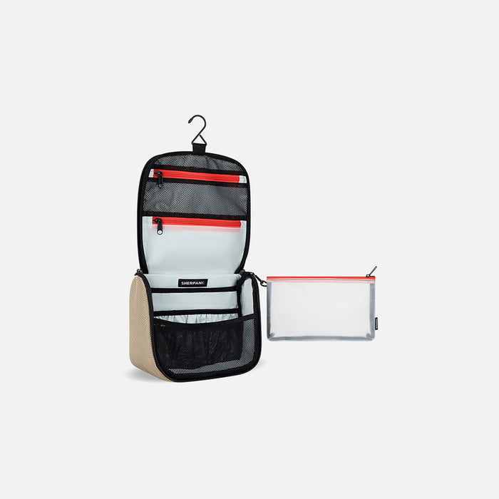 A Sherpani Co-Pilot Straw Beige Travel Toiletry Case, 3/4 open view showing interior pockets against white background. #color_straw-beige