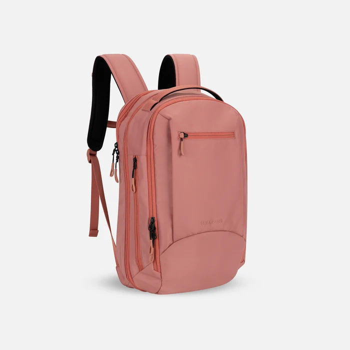A Sherpani Crew Desert Pink Travel Backpack, 3/4 view showing lockable zippers and different straps against a white background. #color_desert-pink