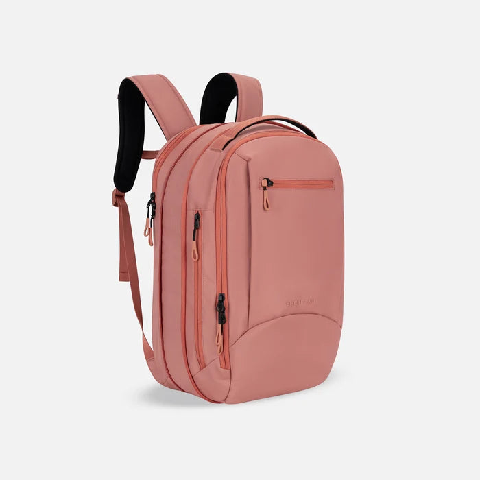 A Sherpani Crew Desert Pink Travel Backpack, 3/4 view showing lockable zippers and the extender pocket against a white background #color_desert-pink