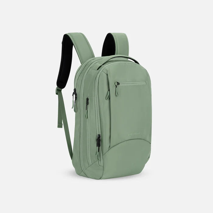 A Sherpani Crew Olivine Travel Backpack, 3/4 view showing lockable zippers and different straps against a white background. #color_olivine-green