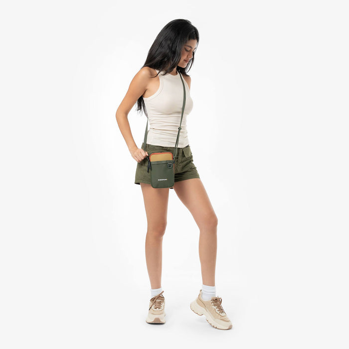 Woman wearing a Sherpani Cruz Antelope Small Crossbody against white backdrop.  #color_antelope