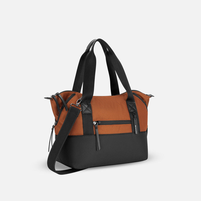 A Sherpani Eclipse Morocco Expandable Tote, 3/4 view showing lockable pocket and strap options on white backdrop. #color_morocco