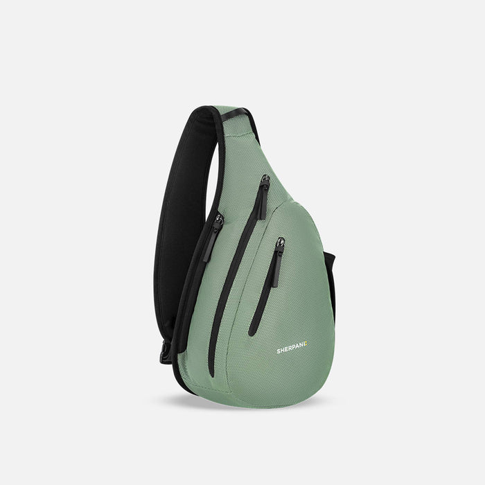 A Sherpani Esprit Aloe Mist Green Anti-theft Sling Bag, 3/4 view showing lockable pockets and main strap on a white background. #color_aloe-mist-green