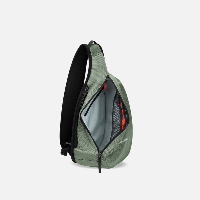 A Sherpani Esprit Aloe Mist Green Anti-theft Sling Bag, side view showing inside main pocket on a white background. #color_aloe-mist-green