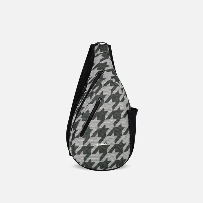 A Sherpani Esprit Houndstooth Anti-theft Sling, front view showing strap & lockable pockets on white backdrop.  #color_houndstooth-print