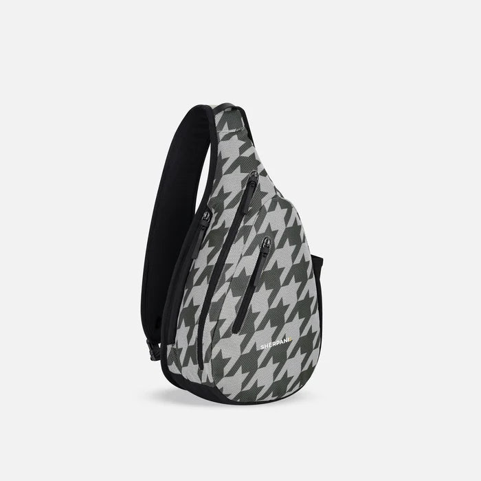 A Sherpani Esprit Houndstooth Anti-theft Sling, 3/4 view showing strap & lockable pockets on white backdrop. #color_houndstooth-print